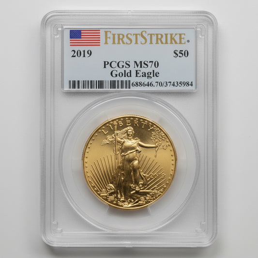 Gold eagle coin in a clear case with 'First Strike' and 'PCGS MS70' labels on a wooden surface.